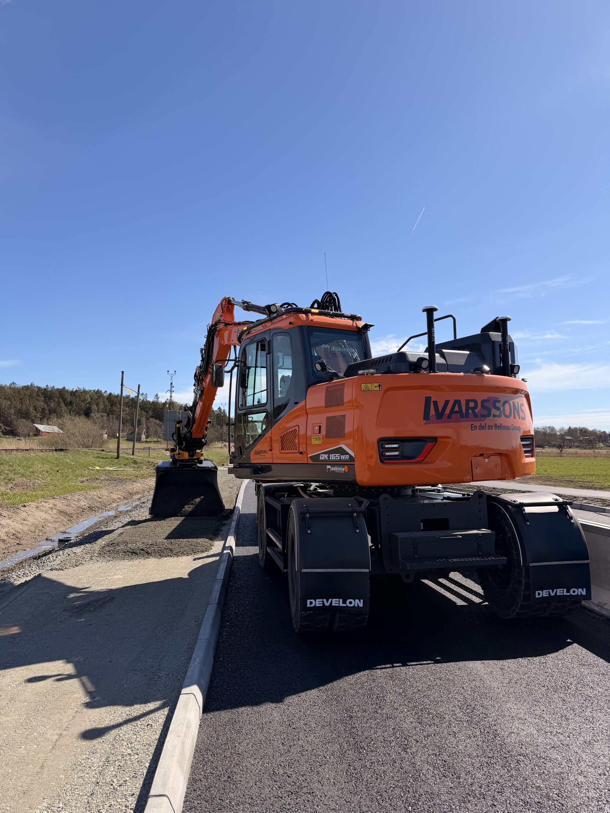 Hjulgrävmaskin Develon DX165 WR justerar nivån för asfaltering i Gunnesby, Säve åt Infrakraft